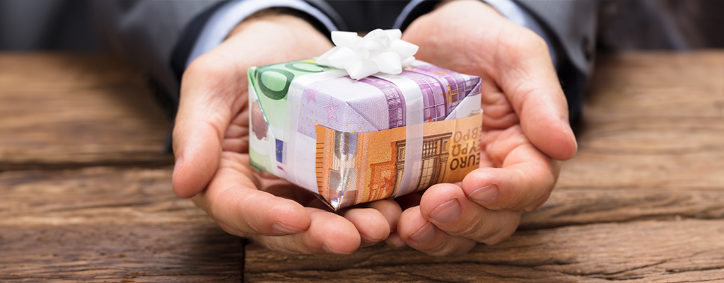 Hand mit Haus aus Geld